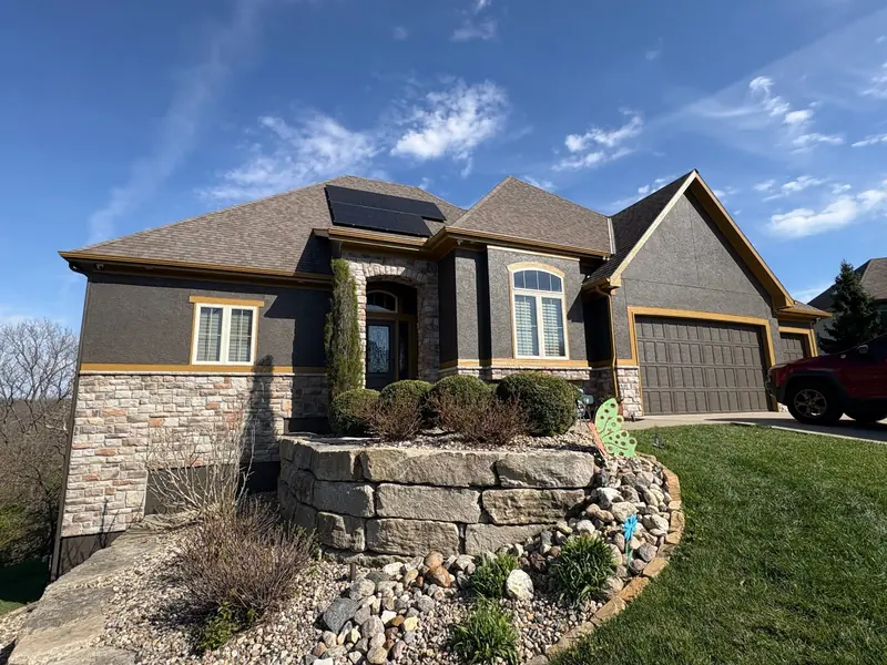After: Tan stucco to bold charcoal with matching garage doors