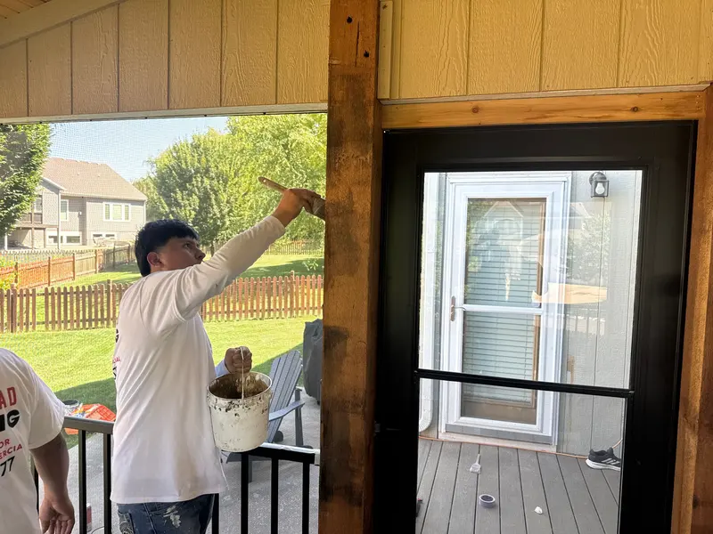 Arrowhead Painting crew member painting a covered porch
