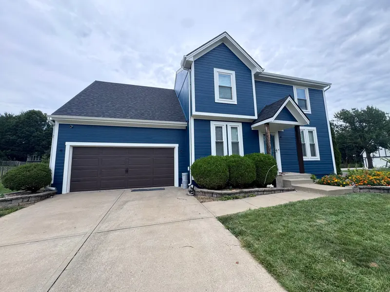 Two-story home painted deep blue with white trim