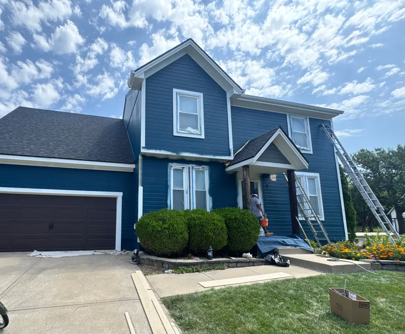 Arrowhead crew painting a two-story home deep blue