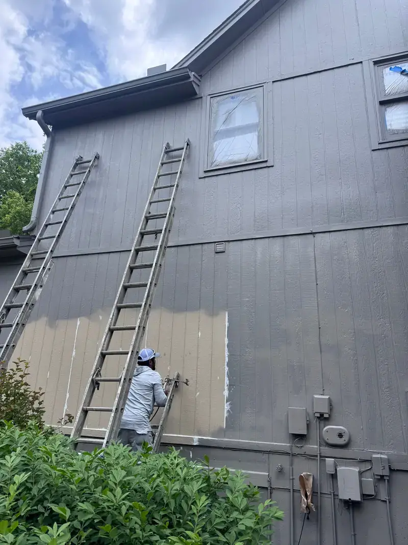 Arrowhead carpenter repairing siding on a ladder