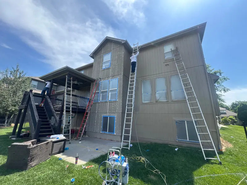 Arrowhead crew on ladders painting a three-story home