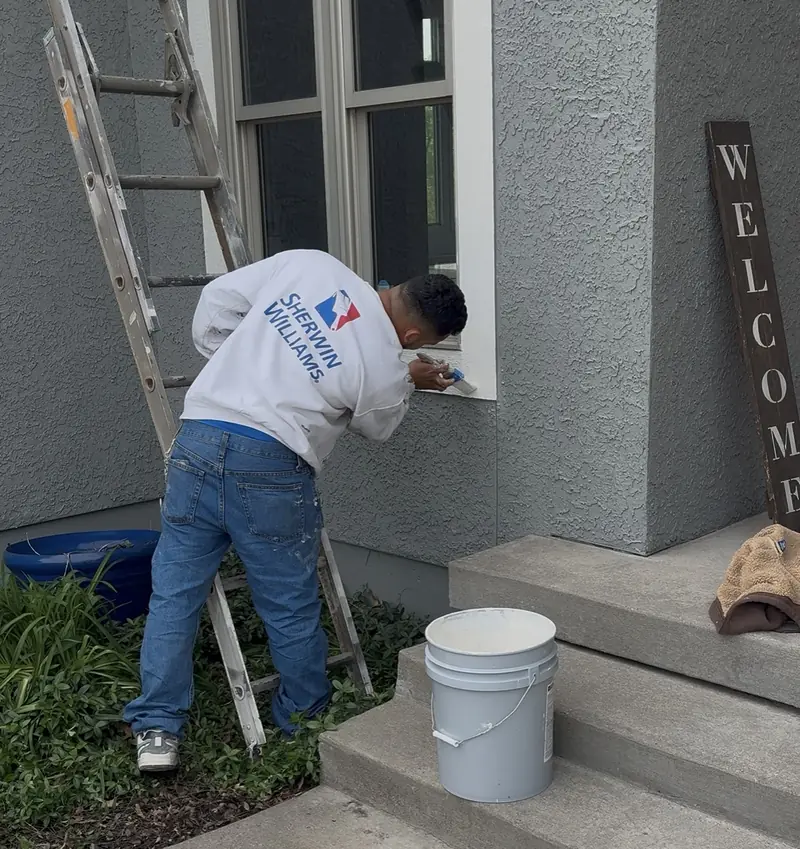 Painter doing detailed touch-ups on window trim