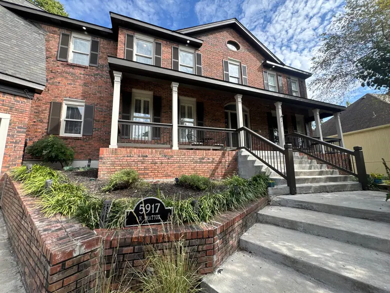 Brick two-story with a freshly painted porch
