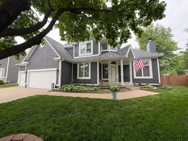 Charcoal two-story with white garage doors