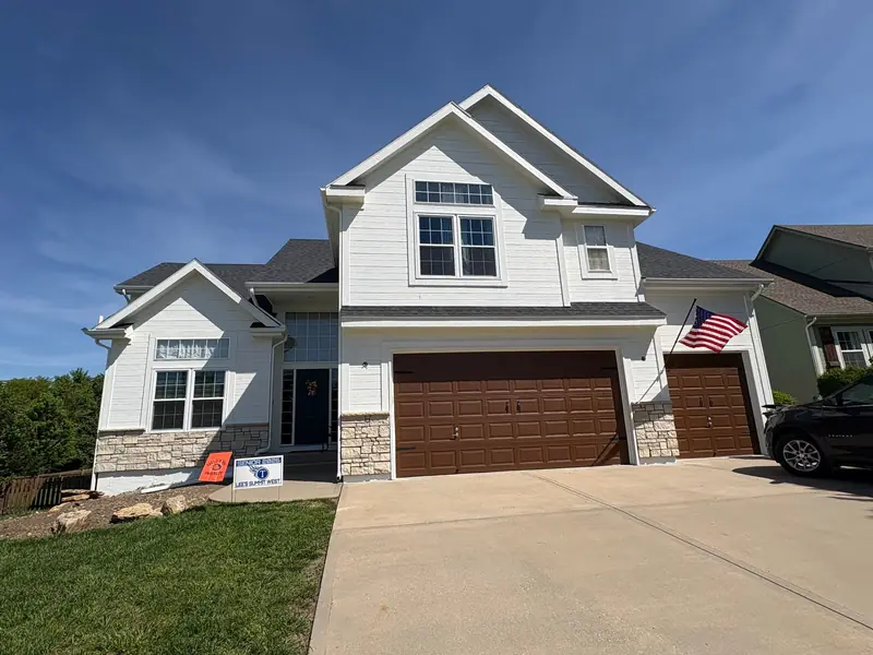 White two-story with brown garage doors