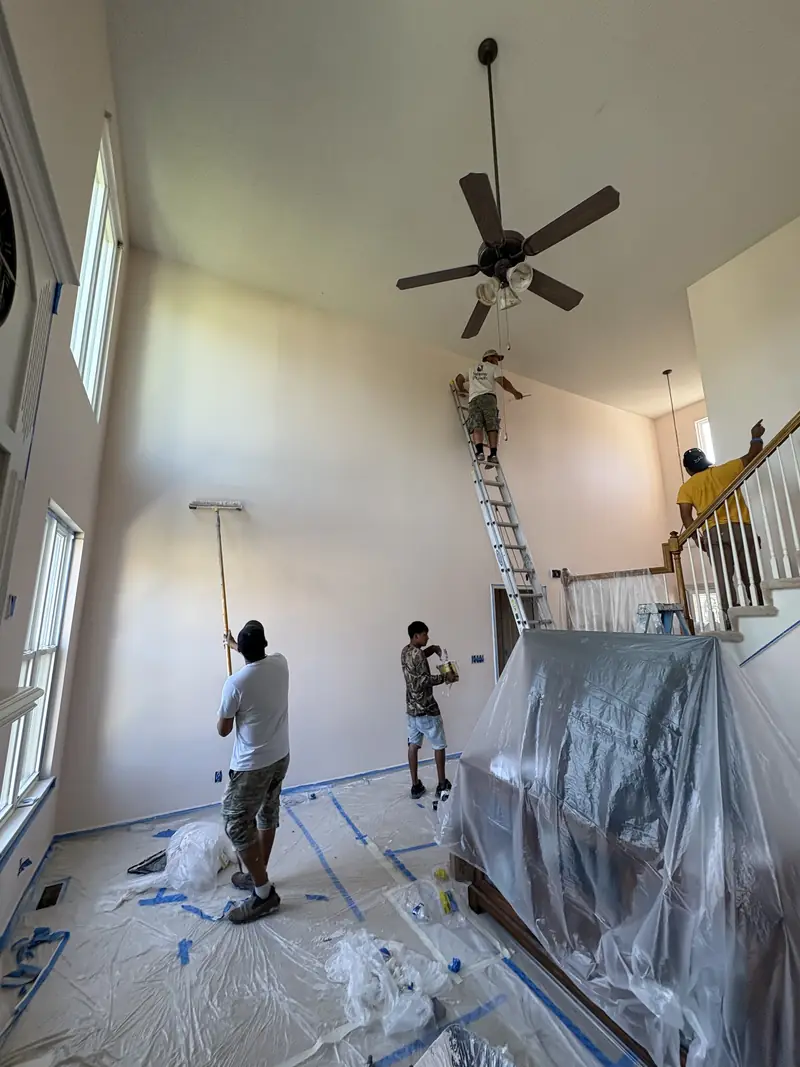 Painters rolling a two-story great room