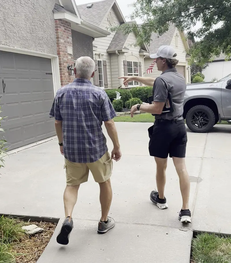 Cade walking a property with a homeowner during an estimate